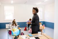 Teacher engaging with students in a bright classroom, promoting a positive learning environment.